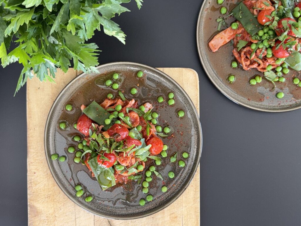 If you’re craving a seafood dish that’s vibrant, spicy, and packed with vegetables — this Calamari All’Arrabbiata is for you. Tender squid, a rich tomato sauce, flat green beans, sweet peas, and bursts of fresh cherry tomatoes: this is Mediterranean comfort on a plate!