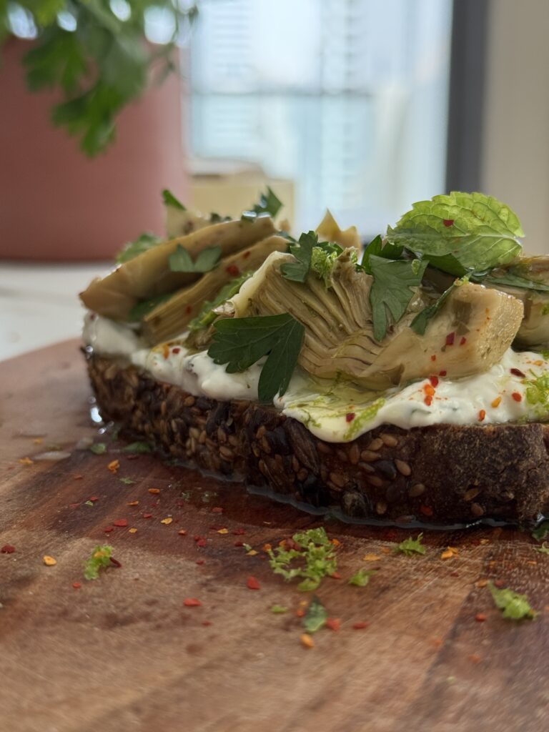 Fresh, zesty, crunchy — and just what you need for a light lunch or chic apéro. Today, we’re making a quick and vibrant bruschetta detox — featuring creamy herbed tzatziki, marinated artichokes, and golden toasted cereal bread. This recipe is super easy, full of flavor, and absolutely gorgeous on the plate. Let’s dive in 💚