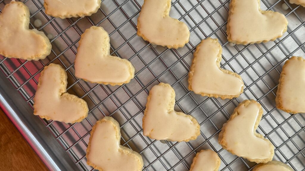 Une recette douce, à préparer en duo pour les goûters de décembre. Il y a des recettes qui sentent Noël rien qu’en ouvrant le four. Ces cœurs sablés en font partie. Une pâte croustillante, un glacage délicatement parfumé à l’orange… et le plaisir simple de cuisiner à deux. Aujourd’hui, jour 4 de notre calendrier de l’Avent culinaire, j’ai préparé ces petits biscuits avec ma fille — une parenthèse douce, calme, remplie de rires et de farine partout. Des moments à garder précieusement, comme une tradition d’hiver.