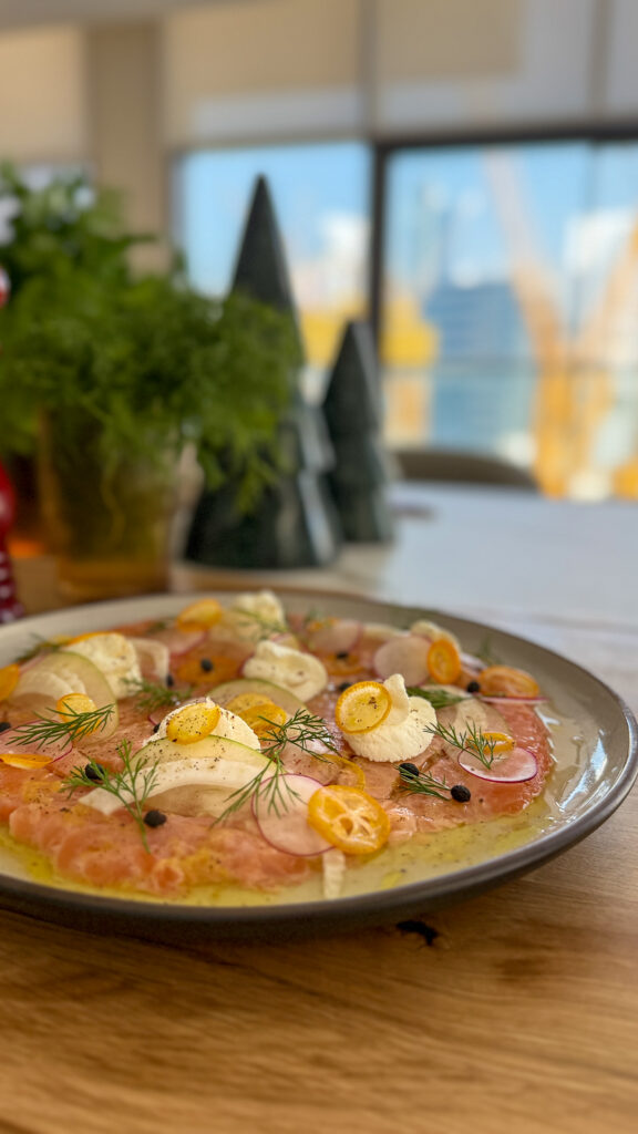 Carpaccio de saumon, pomme verte, radis, kumquat & crème légère au citron Un plat frais, délicat et ultra coloré — parfait pour illuminer une table d’hiver. Il y a quelque chose de magique dans un carpaccio bien dressé : les couleurs vives, la fraîcheur qui réveille le palais, et cette sensation de légèreté qui donne envie de reprendre une bouchée. Aujourd’hui, je te propose un carpaccio de saumon twisté avec des fruits et légumes croquants, relevé d’une crème légère au citron qui apporte douceur et équilibre. C’est un plat raffiné mais simple à préparer, idéal pour un dîner de fêtes, un apéritif chic ou une entrée de Noël moderne et subtilement parfumée.